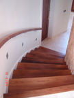 Concrete curved stairs wrapped in walnut with matching handrails